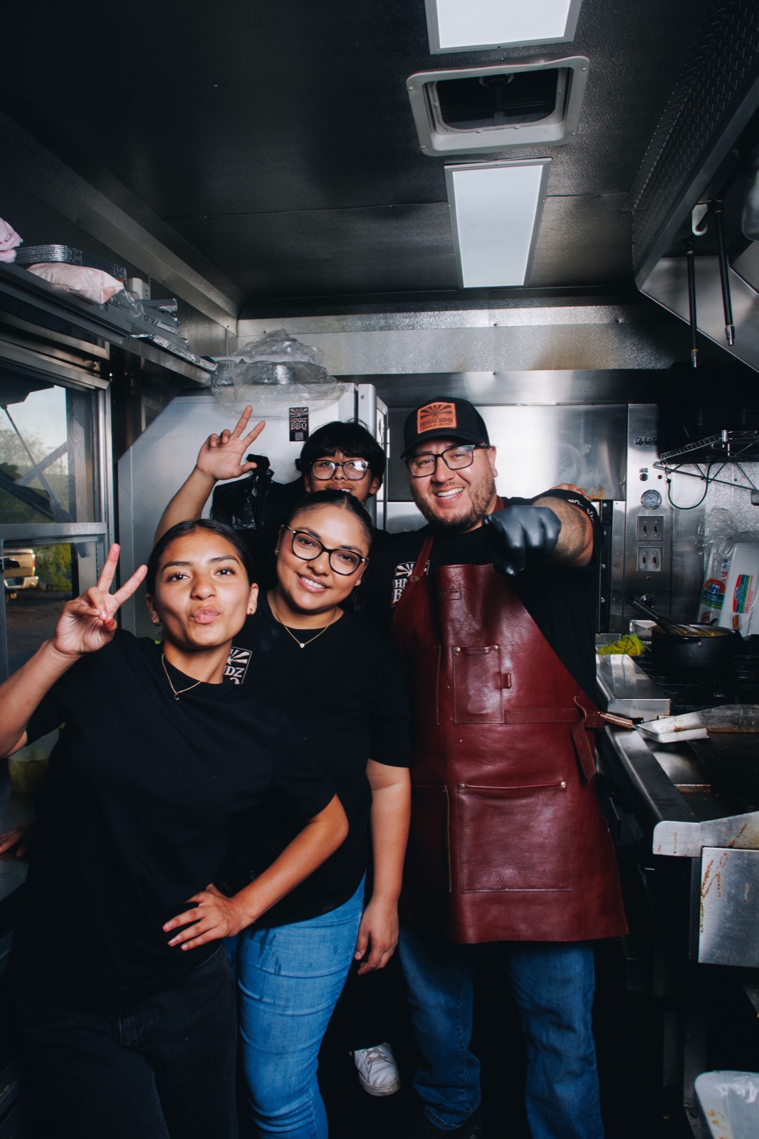 The HNDZ BBQ crew together inside the food truck